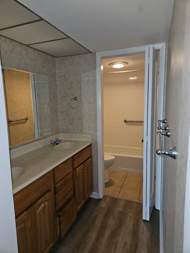 full bathroom with wood-type flooring, vanity, shower / bath combination, and toilet