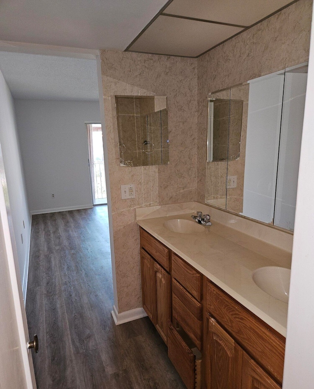 bathroom featuring wood-type flooring, a shower, and vanity