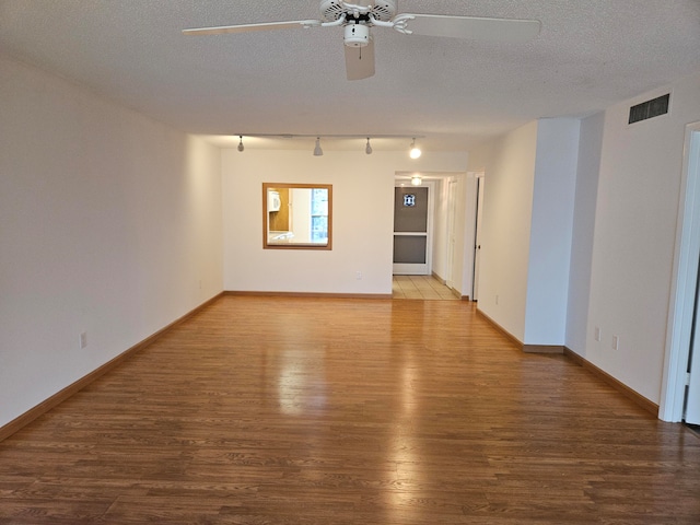 empty room featuring ceiling fan, hardwood / wood-style flooring, and a textured ceiling