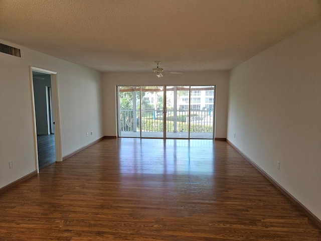 empty room featuring a textured ceiling, dark hardwood / wood-style floors, and ceiling fan