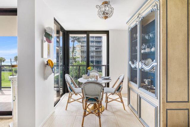 3440 S Ocean Blvd Unit 201N, Palm Beach, FL 33480 - dining area featuring expansive windows, light tile patterned flooring, baseboards, and a chandelier