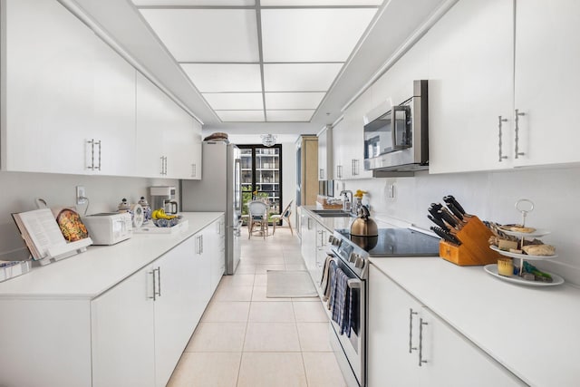 3440 S Ocean Blvd Unit 201N, Palm Beach, FL 33480 - kitchen featuring stainless steel appliances, light tile patterned flooring, white cabinets, and light countertops
