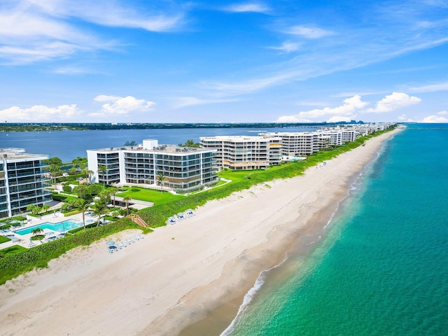 birds eye view of property with a water view and a beach view