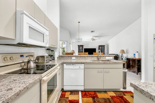 kitchen with ceiling fan, white appliances, sink, lofted ceiling, and kitchen peninsula