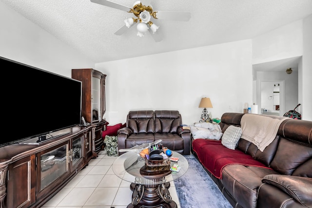 living room with ceiling fan, a textured ceiling, and light tile patterned floors