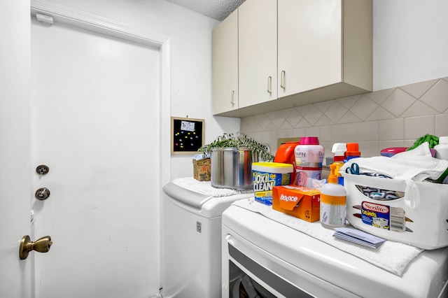 washroom featuring washing machine and dryer and cabinets