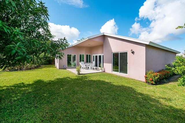 back of house with a lawn and a patio area