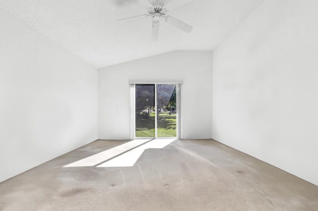 unfurnished room with ceiling fan, lofted ceiling, and carpet flooring