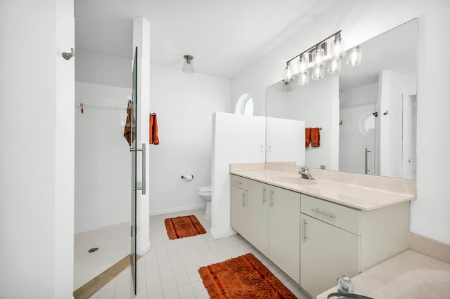 bathroom featuring tiled shower, tile patterned floors, vanity, and toilet