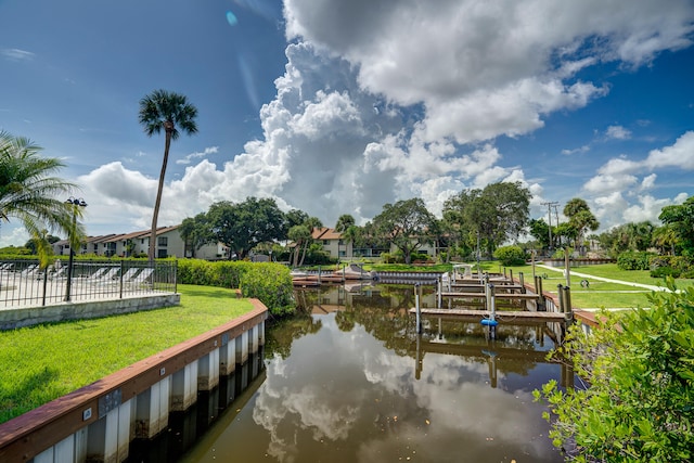 view of dock featuring a water view and a yard