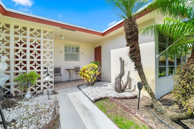 view of exterior entry with a patio area