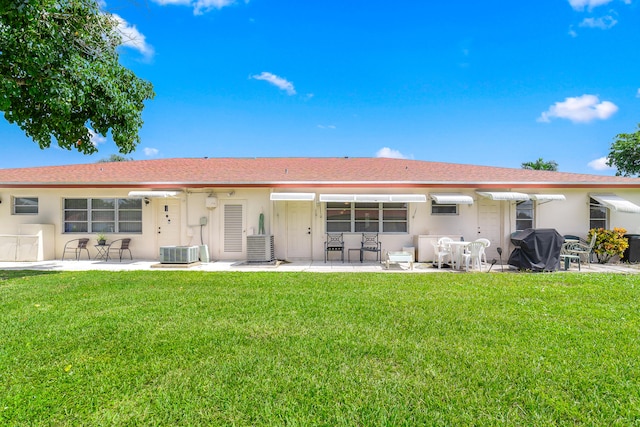 rear view of property featuring a patio, a yard, and central AC