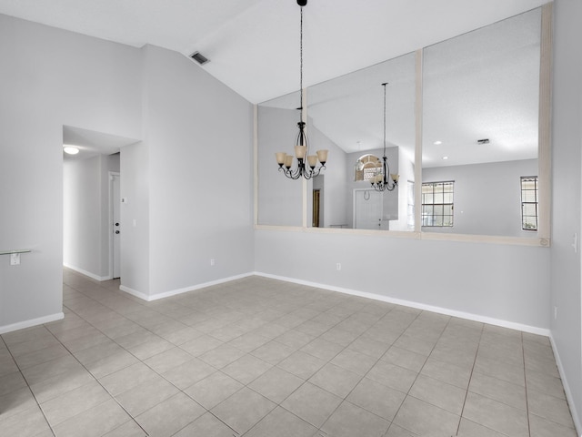 tiled empty room featuring a notable chandelier and lofted ceiling