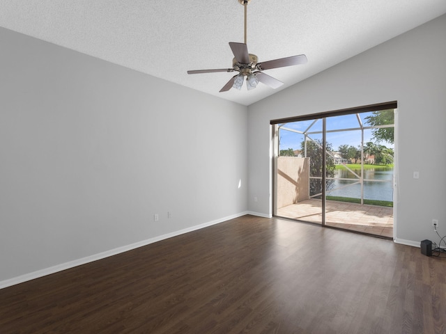 empty room with a water view, ceiling fan, a textured ceiling, lofted ceiling, and dark wood-type flooring