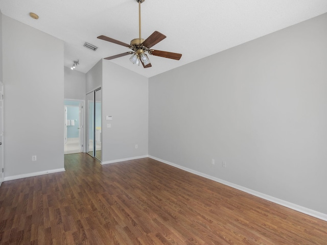 spare room featuring dark wood-type flooring, ceiling fan, and vaulted ceiling