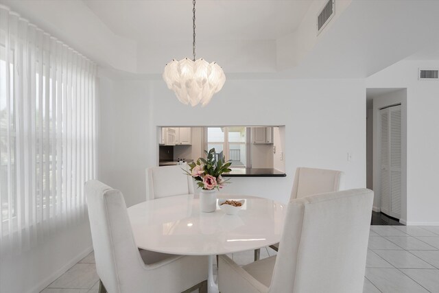 empty room featuring a water view, ceiling fan, and light tile patterned floors