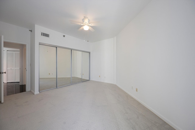 unfurnished bedroom featuring carpet floors, ceiling fan, and a closet