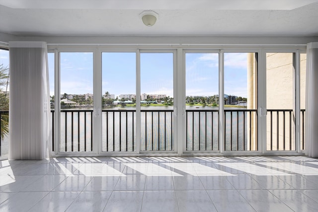 unfurnished sunroom with a water view and a wealth of natural light