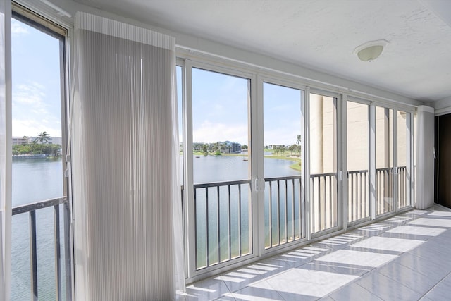 sunroom with a wealth of natural light and a water view