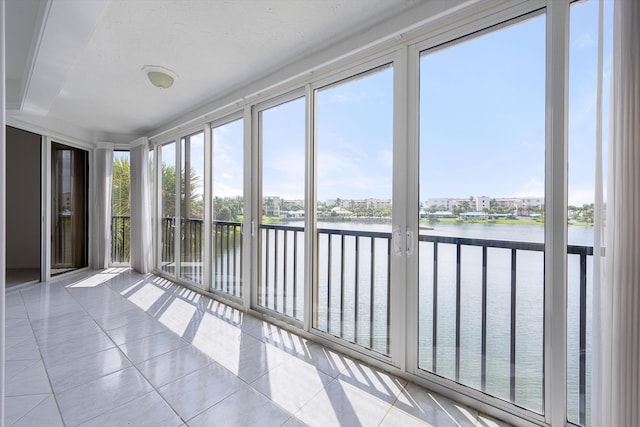 unfurnished sunroom featuring a water view and a wealth of natural light