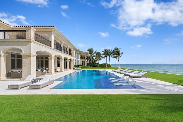 view of pool with a patio, outdoor lounge area, a yard, and a water view