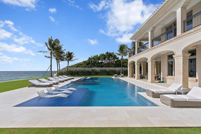 view of pool with a patio and a water view