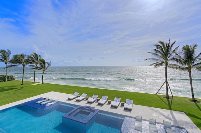 view of swimming pool featuring a water view, a patio area, and a lawn