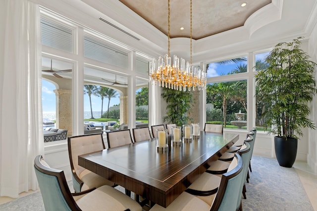 dining area featuring crown molding, a tray ceiling, and ceiling fan with notable chandelier