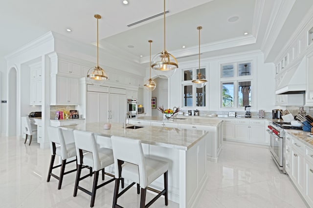 kitchen featuring a spacious island, hanging light fixtures, white cabinetry, decorative backsplash, and high end appliances