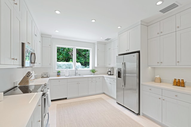 kitchen featuring sink, appliances with stainless steel finishes, and white cabinets