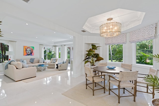 dining area with a notable chandelier, ornamental molding, and a tray ceiling