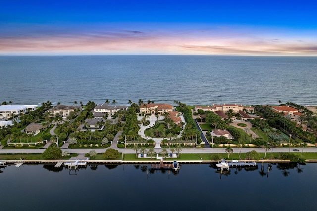 aerial view at dusk featuring a water view