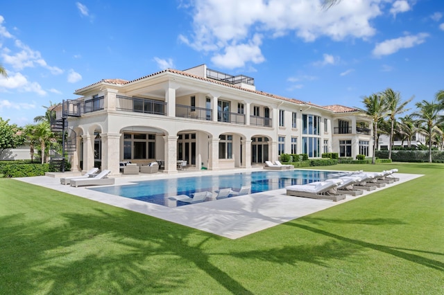 rear view of property with a patio area, a lawn, and a balcony