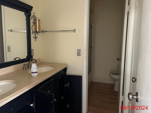 full bathroom featuring shower with separate bathtub, vanity, toilet, and hardwood / wood-style flooring