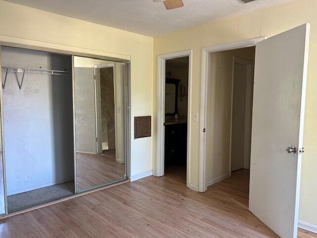 unfurnished bedroom with light hardwood / wood-style flooring and a closet