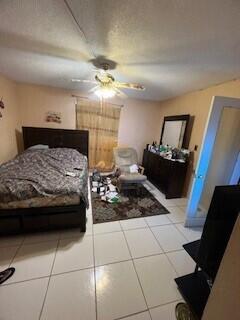 bedroom with ceiling fan and light tile patterned floors