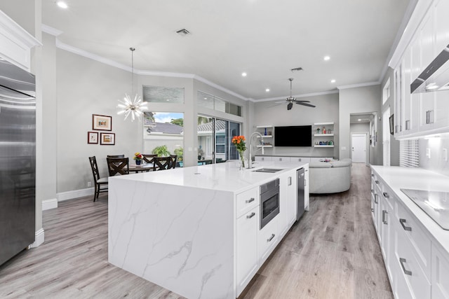 kitchen featuring a kitchen island with sink, sink, light hardwood / wood-style floors, white cabinetry, and stainless steel appliances