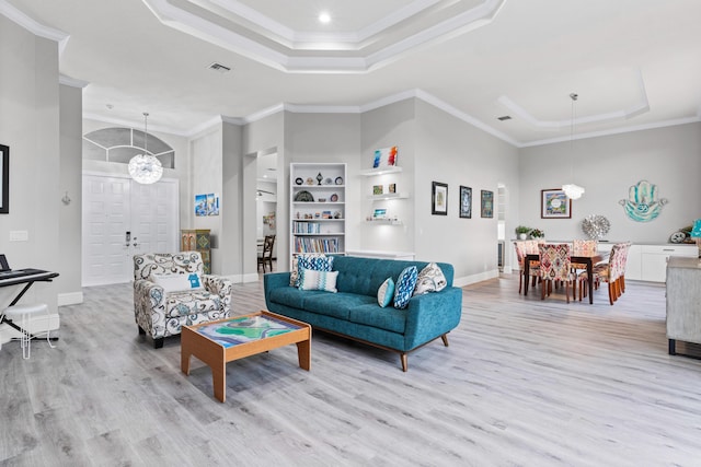 living room featuring a chandelier, crown molding, and light hardwood / wood-style floors