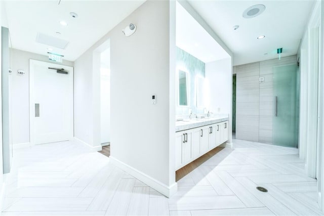 bathroom with tiled shower and vanity