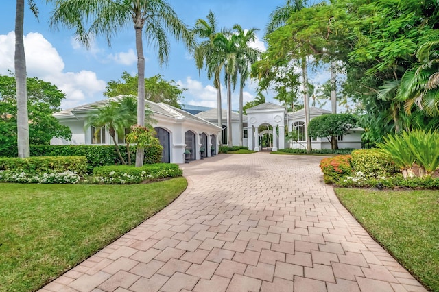 mediterranean / spanish-style house with a front yard and a garage