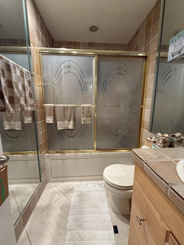 full bathroom featuring tile patterned flooring, vanity, bath / shower combo with glass door, and toilet