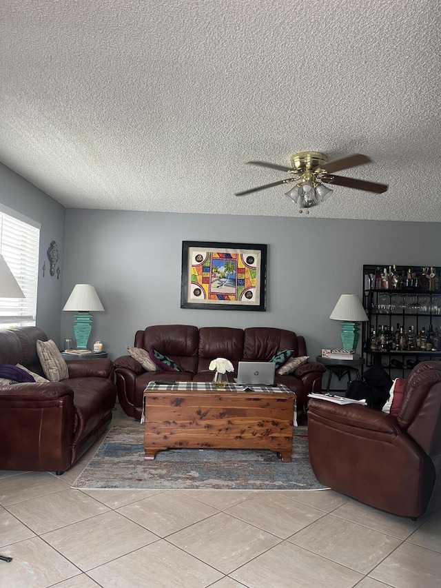 living room featuring light tile patterned floors, a textured ceiling, and ceiling fan