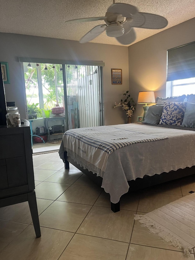 tiled bedroom with multiple windows, a textured ceiling, and ceiling fan