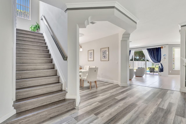 foyer entrance with light hardwood / wood-style floors and crown molding