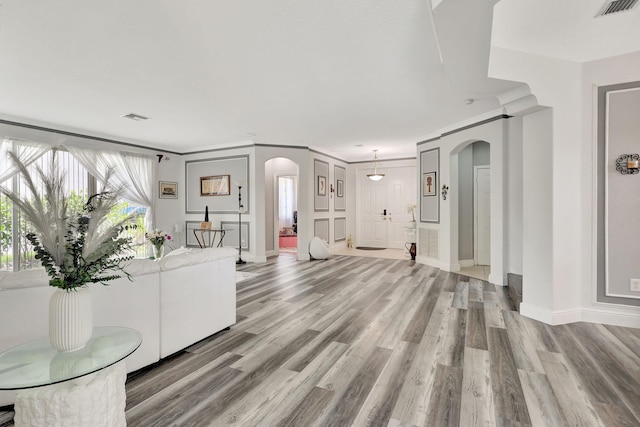 living room featuring ornamental molding and light hardwood / wood-style flooring