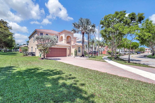 mediterranean / spanish house featuring a front yard and a garage