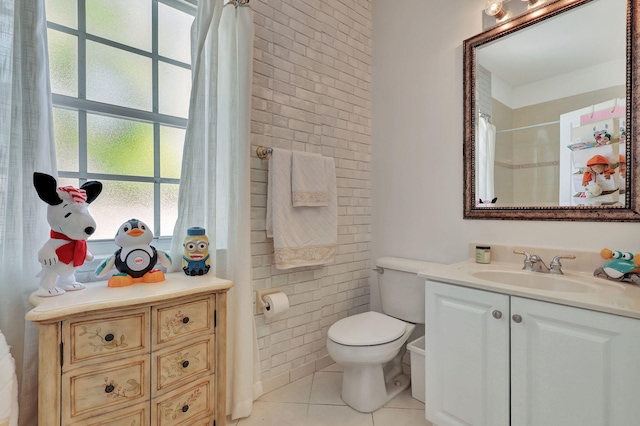 bathroom featuring toilet, tile patterned flooring, vanity, curtained shower, and tile walls