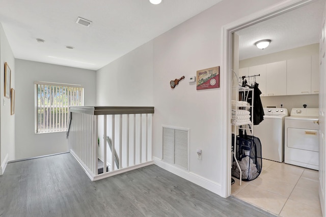 hallway featuring light hardwood / wood-style floors and separate washer and dryer