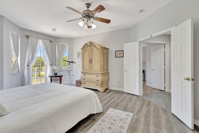 bedroom featuring light hardwood / wood-style flooring, access to exterior, and ceiling fan