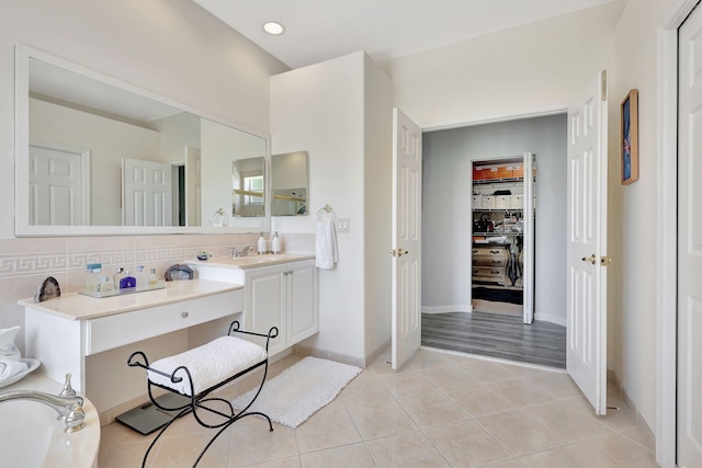 bathroom featuring vanity, tasteful backsplash, tile patterned floors, and a bath